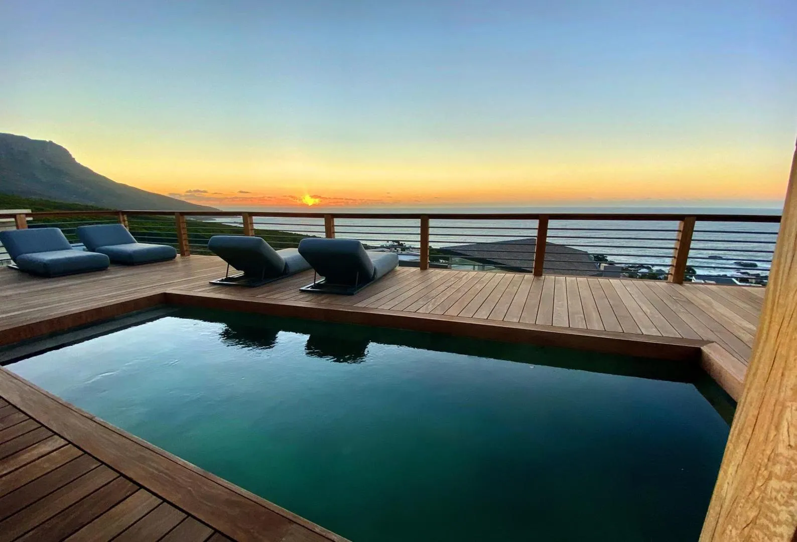Pool at sunset with loungers above the Atlantic
