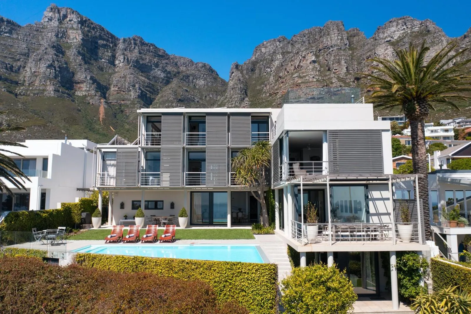 Villa exterior with pool below and the mountains rising behind